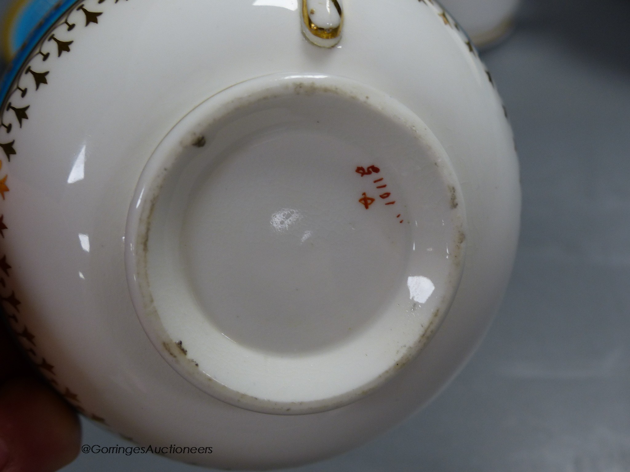 A Minton coffee cup, teacup and saucer with turquoise and gold jewelled band under a gold acid etched border, a matching coffee cup and saucer and a bowl